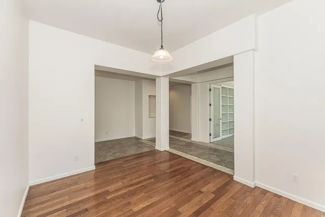 a view of empty room with wooden floor and fireplace