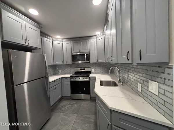 a kitchen with a sink a refrigerator and cabinets