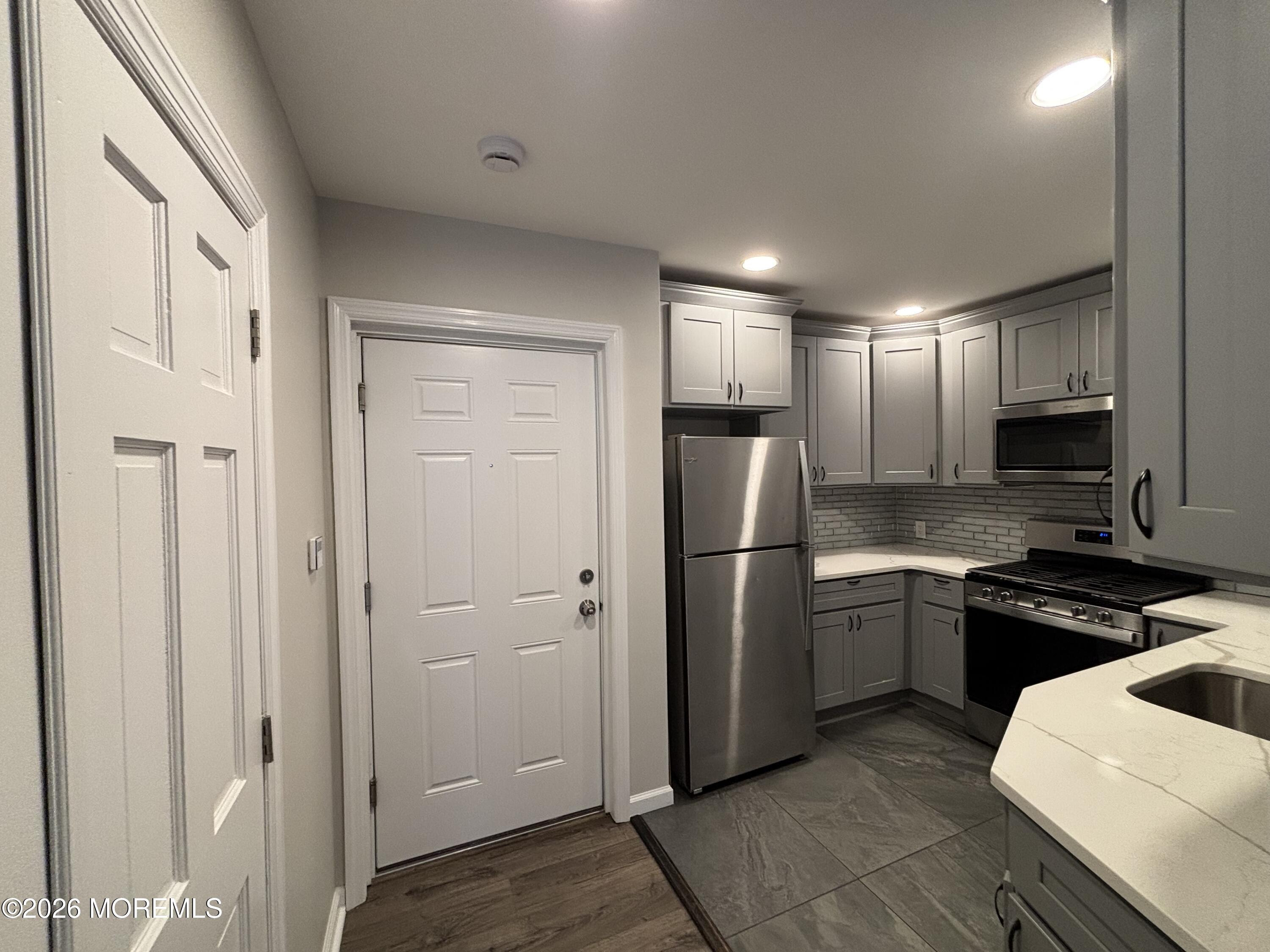 100 Market Yard, Unit 1 Freehold, NJ 07728 - Photo 3 of 12 a kitchen with stainless steel appliances granite countertop a refrigerator and a stove top oven