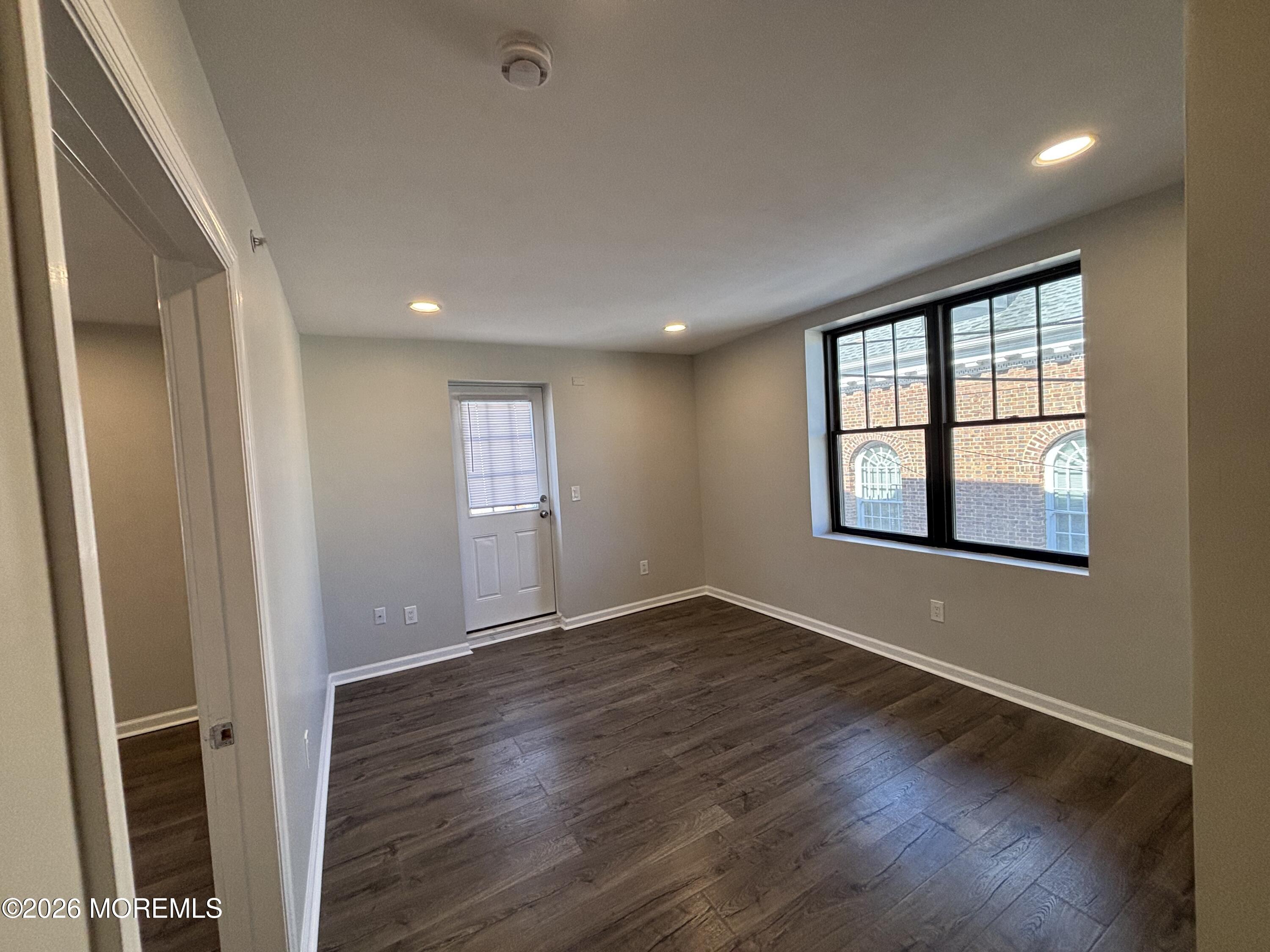 100 Market Yard, Unit 1 Freehold, NJ 07728 - Photo 7 of 12 an empty room with wooden floor and windows