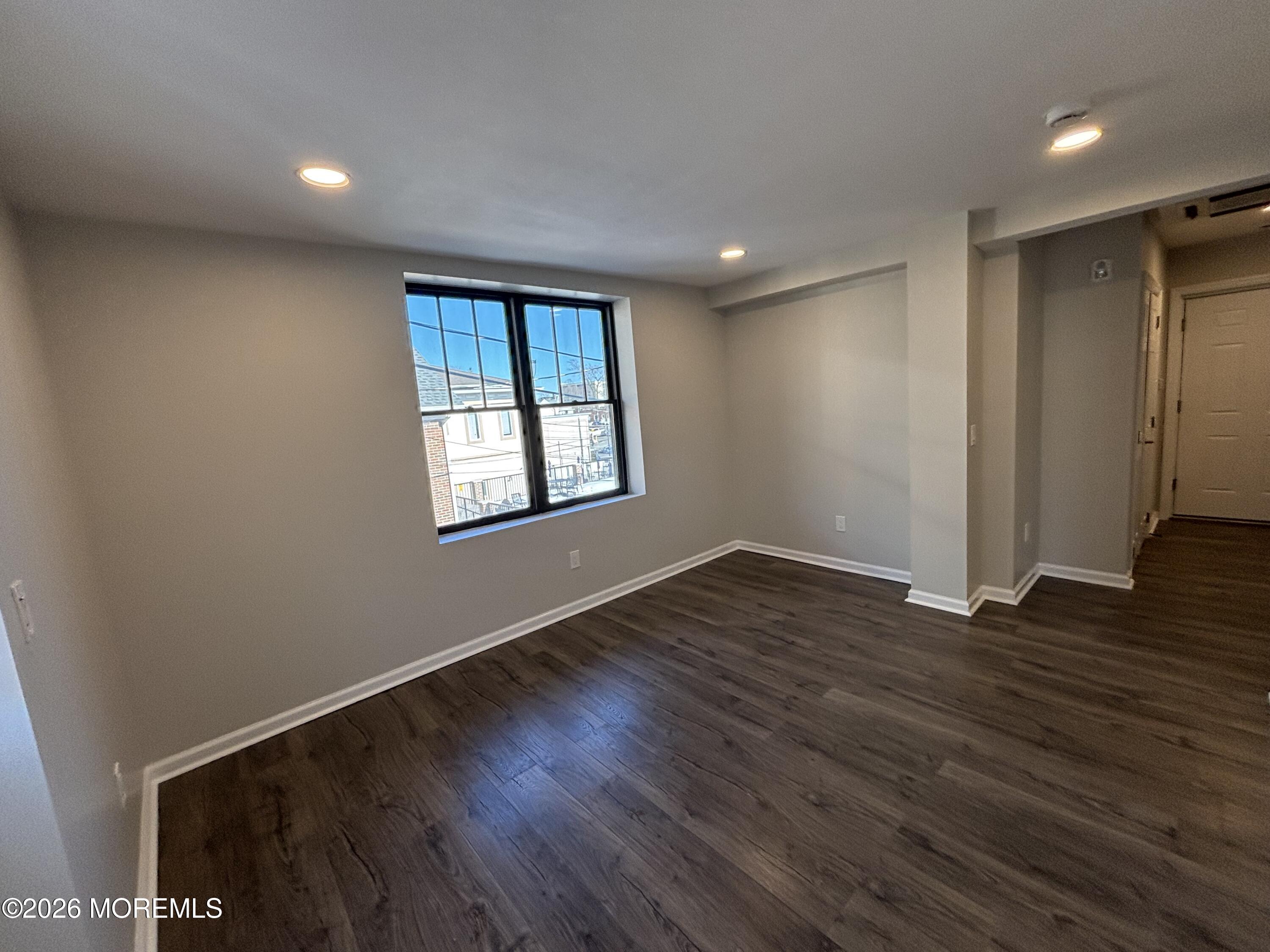 100 Market Yard, Unit 1 Freehold, NJ 07728 - Photo 8 of 12 a view of an empty room with wooden floor and a window