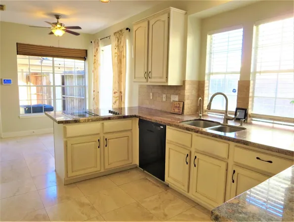 a kitchen with sink a window and cabinets