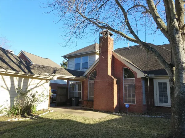 a front view of a house with a garden and trees