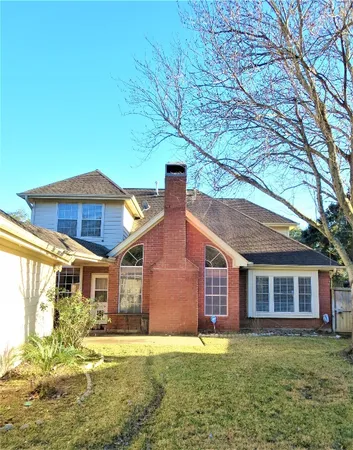 a view of a yard in front of a house with large tree