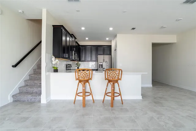 a view of kitchen with stainless steel appliances refrigerator stove microwave and cabinets