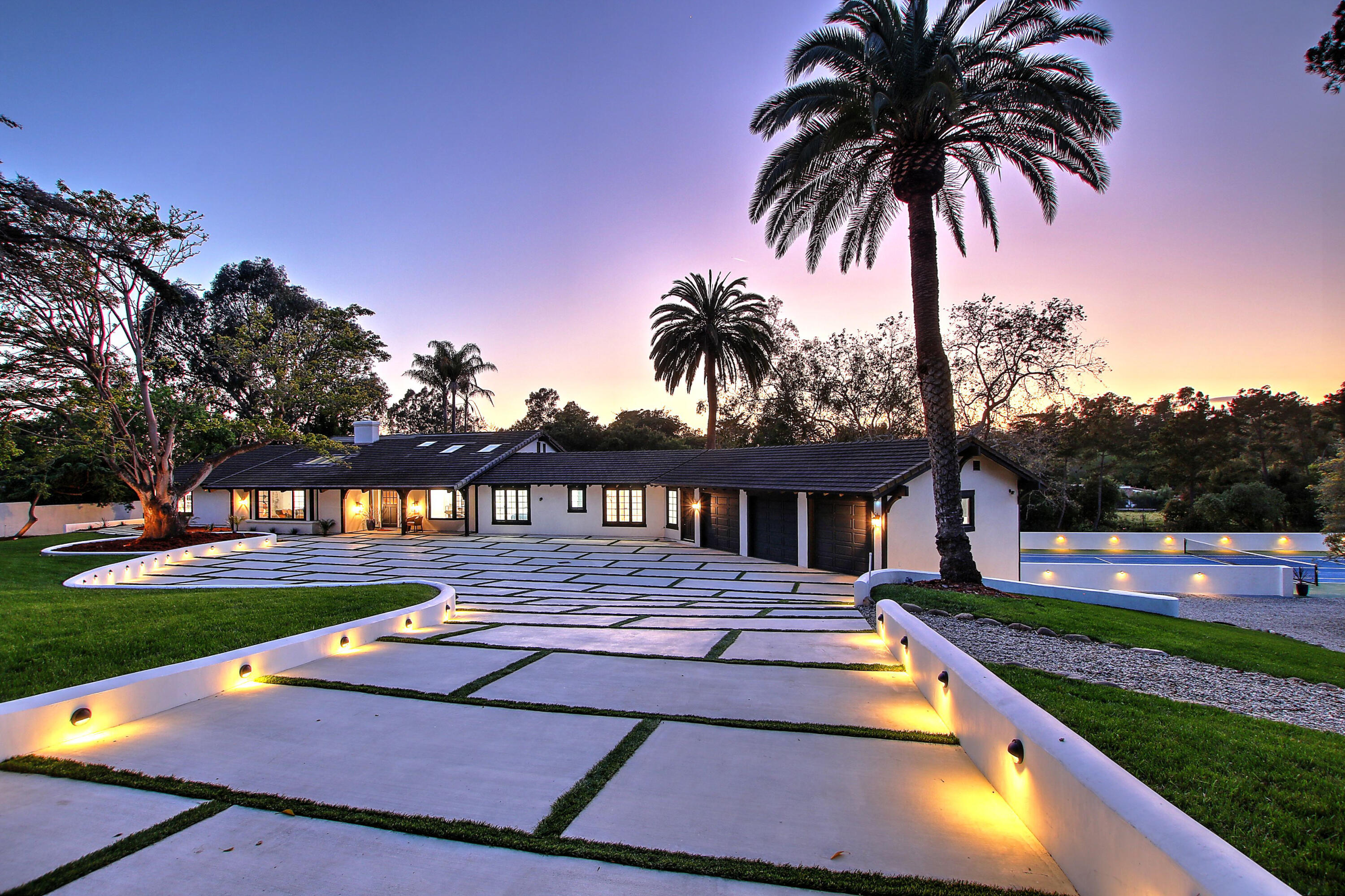 a view of swimming pool with a yard and palm trees