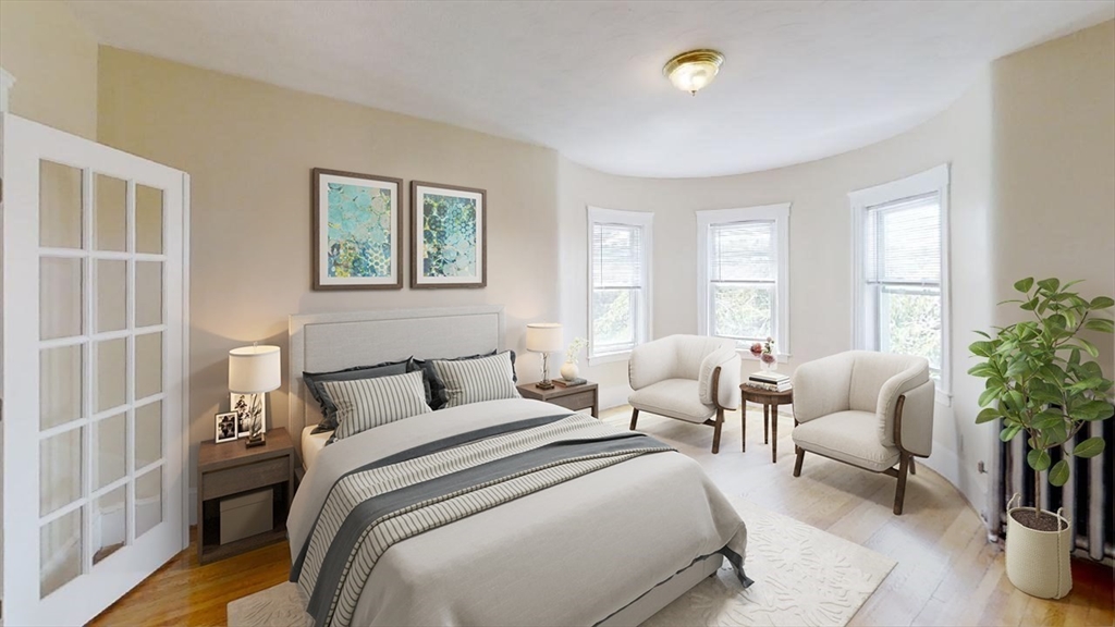 303 Tappan Street, Unit 3 Brookline, MA 02445 - Photo 5 of 10 a bedroom with a large bed and a couch