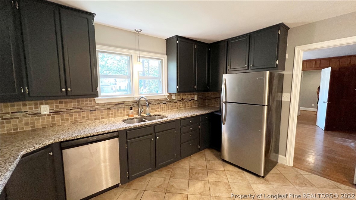 516 Valley Road Fayetteville, NC 28305 - Photo 14 of 48 a kitchen with a refrigerator sink and cabinets