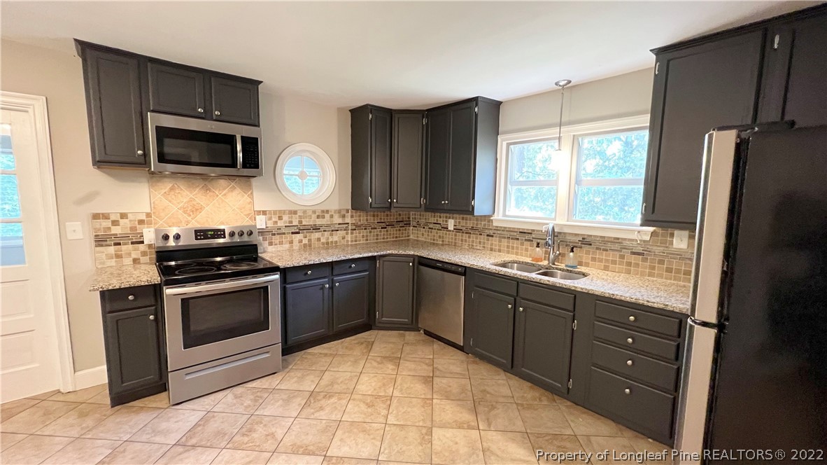 516 Valley Road Fayetteville, NC 28305 - Photo 16 of 48 a kitchen with granite countertop a sink stainless steel appliances and cabinets