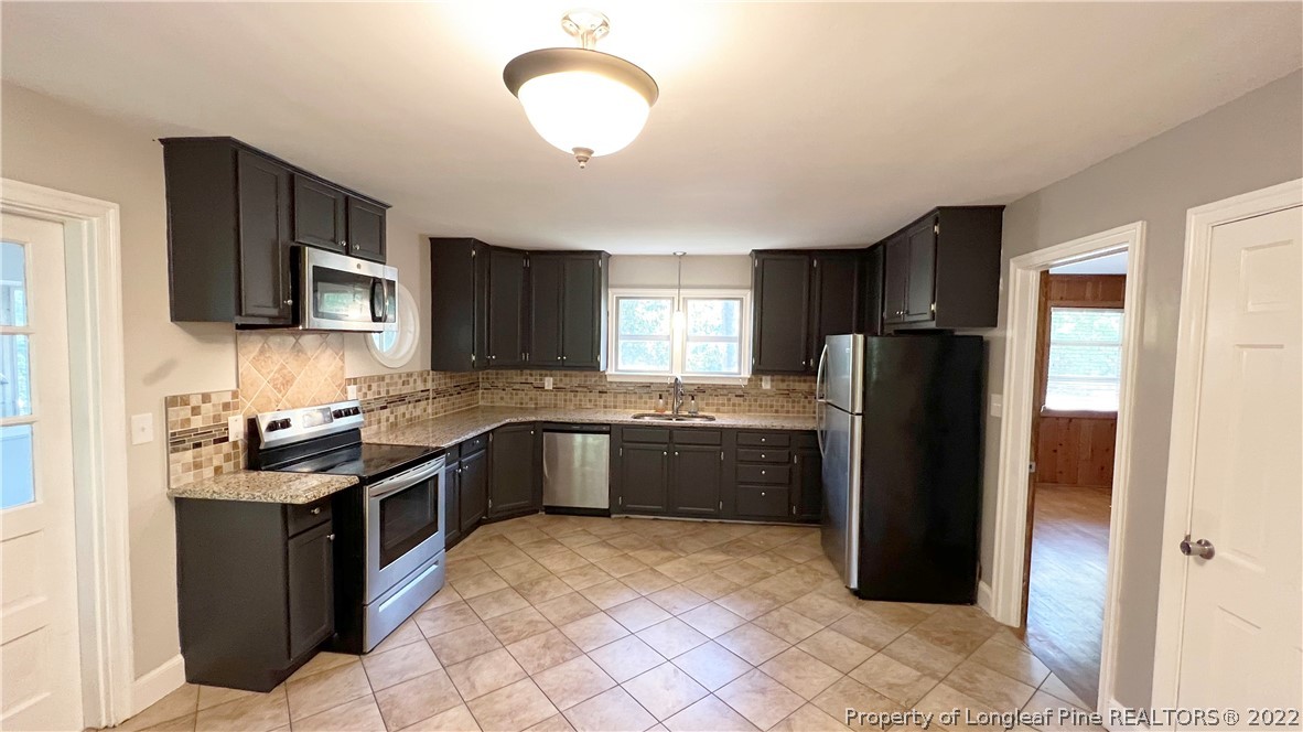 516 Valley Road Fayetteville, NC 28305 - Photo 17 of 48 a kitchen with stainless steel appliances granite countertop a refrigerator stove top oven a sink and dishwasher