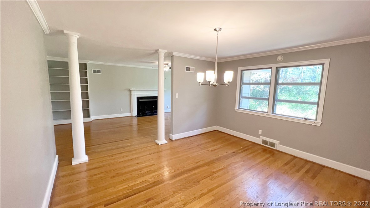 516 Valley Road Fayetteville, NC 28305 - Photo 9 of 48 an empty room with wooden floor chandelier and windows
