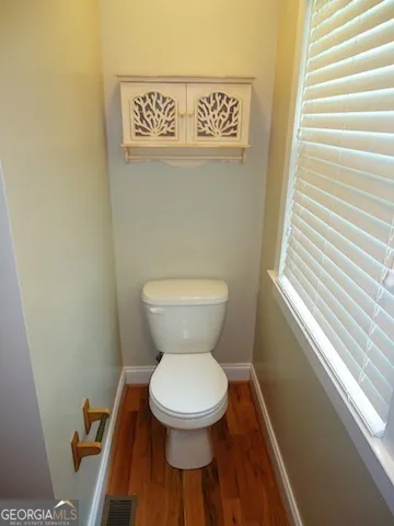 a toilet sitting in a bathroom next to a window