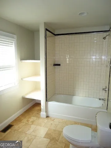 a bathroom with a bathtub toilet and shower