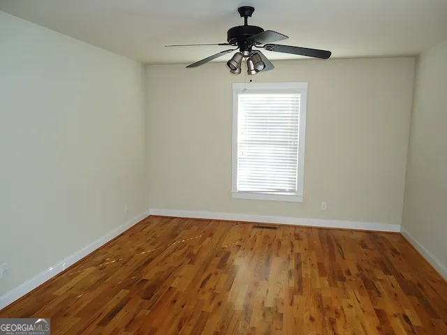 an empty room with a window and a ceiling fan
