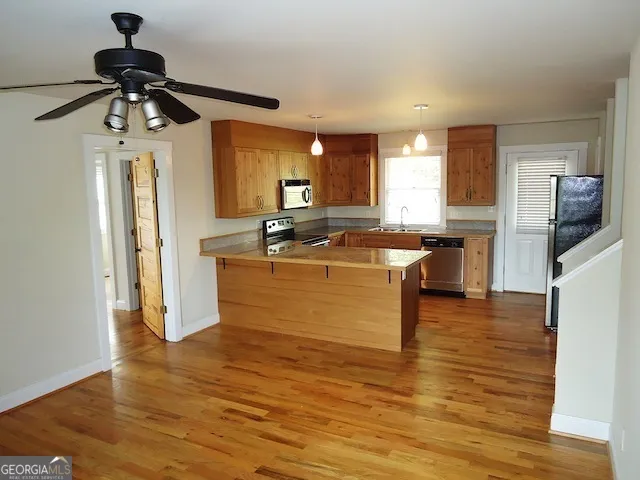 a kitchen with stainless steel appliances granite countertop a sink a stove and refrigerator