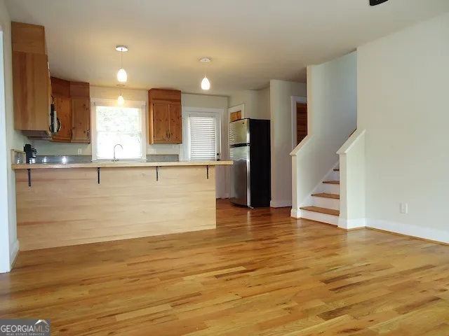 a view of a kitchen with wooden floor and a refrigerator