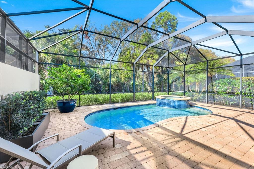 6573 Roma Way Naples, FL 34113 - Photo 32 of 49 View of swimming pool featuring an in ground hot tub, a patio, and glass enclosure