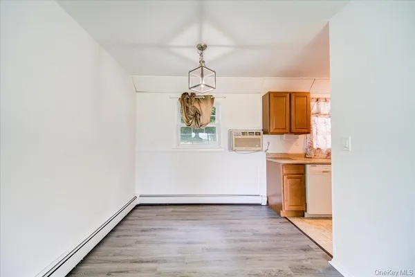 a view of a kitchen with a sink and dishwasher with wooden floor