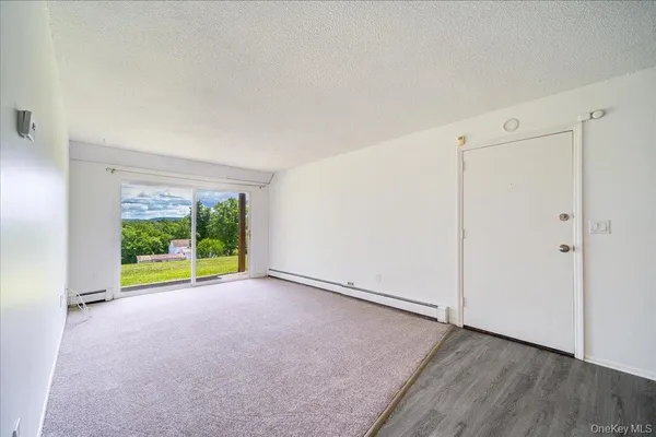 a view of an empty room with a window and an empty room
