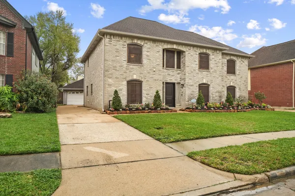 a view of a house with backyard and a tree