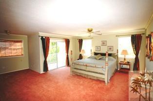 35680 Butterfly Peak Road Mountain Center, CA 92561 - Photo 17 of 19 a spacious bedroom with a large bed and a chandelier