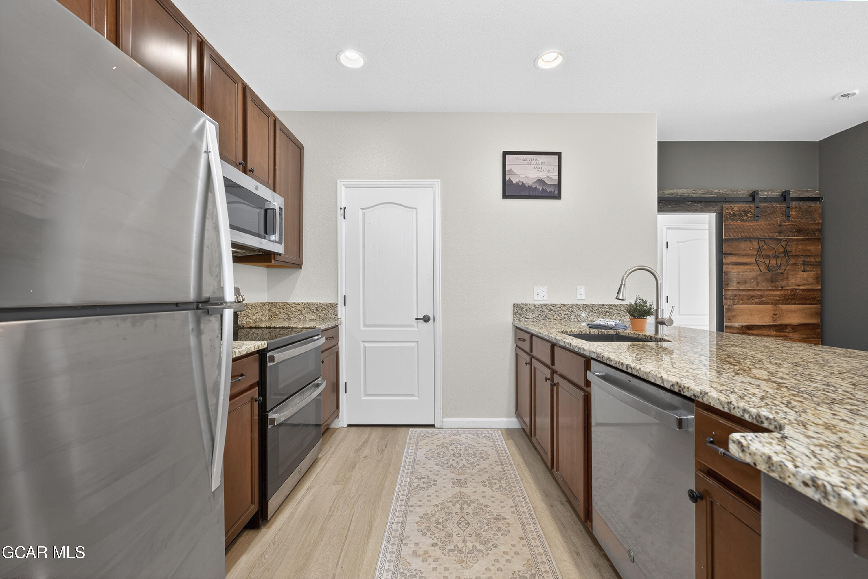158 Village Road Granby, CO 80446 - Photo 3 of 46 a kitchen with granite countertop a sink stove and refrigerator