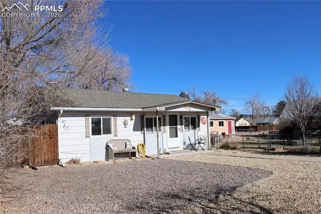 a view of a white house with a big yard and large trees