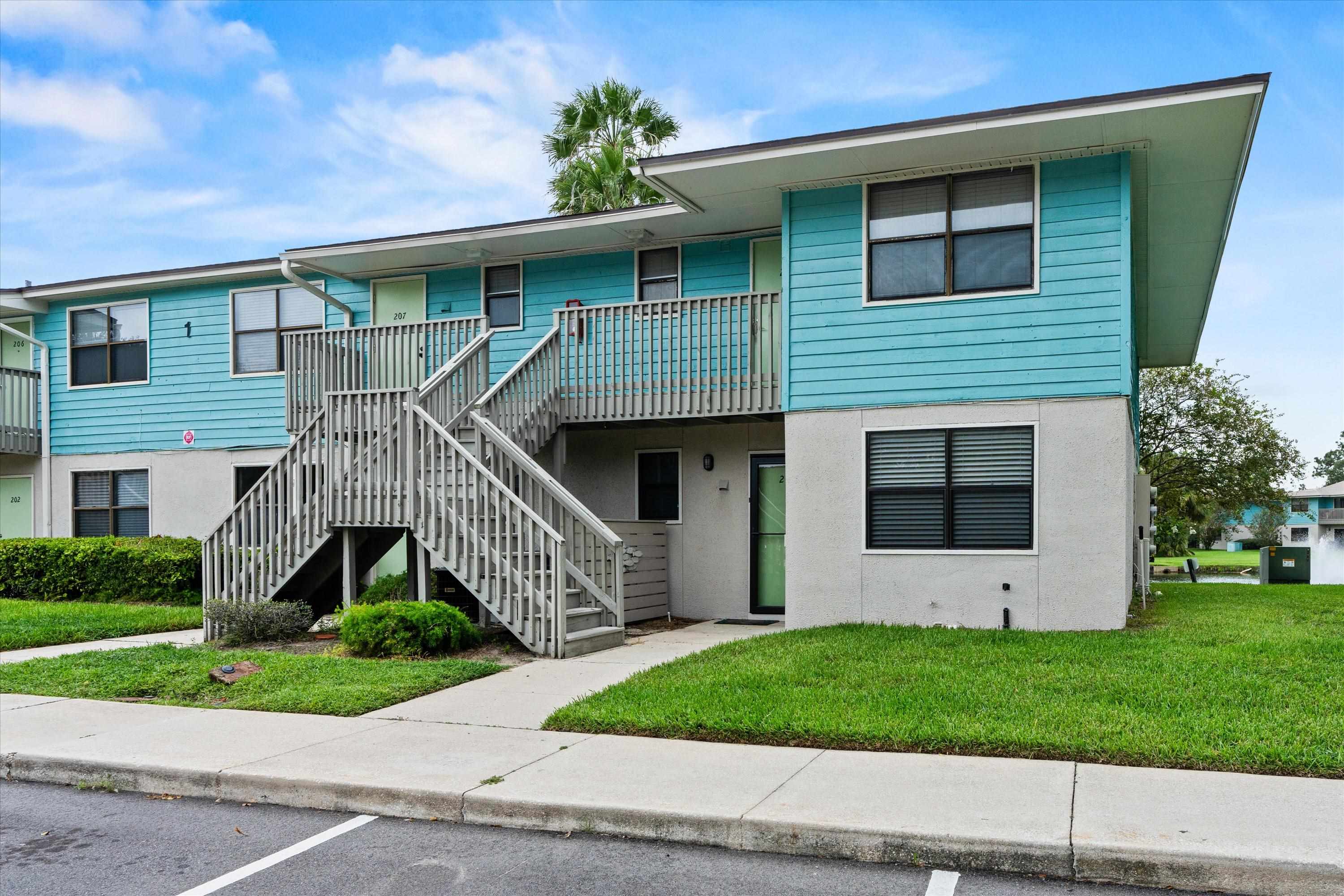 650 West Pope Road, Unit 208 St. Augustine, FL 32080 - Photo 2 of 35 a front view of a house with a garden and plants