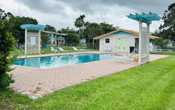 a view of a house with backyard and a tree