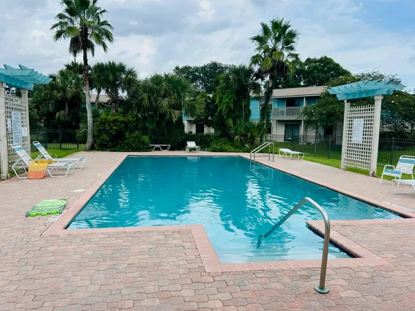 a view of swimming pool with a patio and a garden