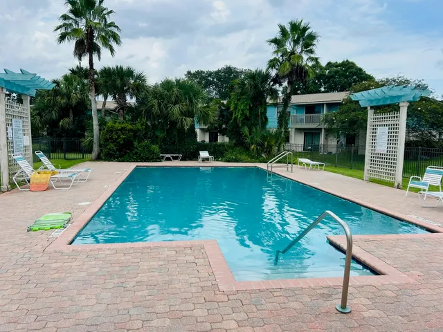 a view of swimming pool with a patio and a garden