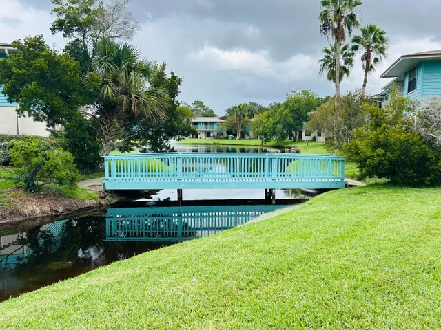 a view of a garden with a bench in front of the house