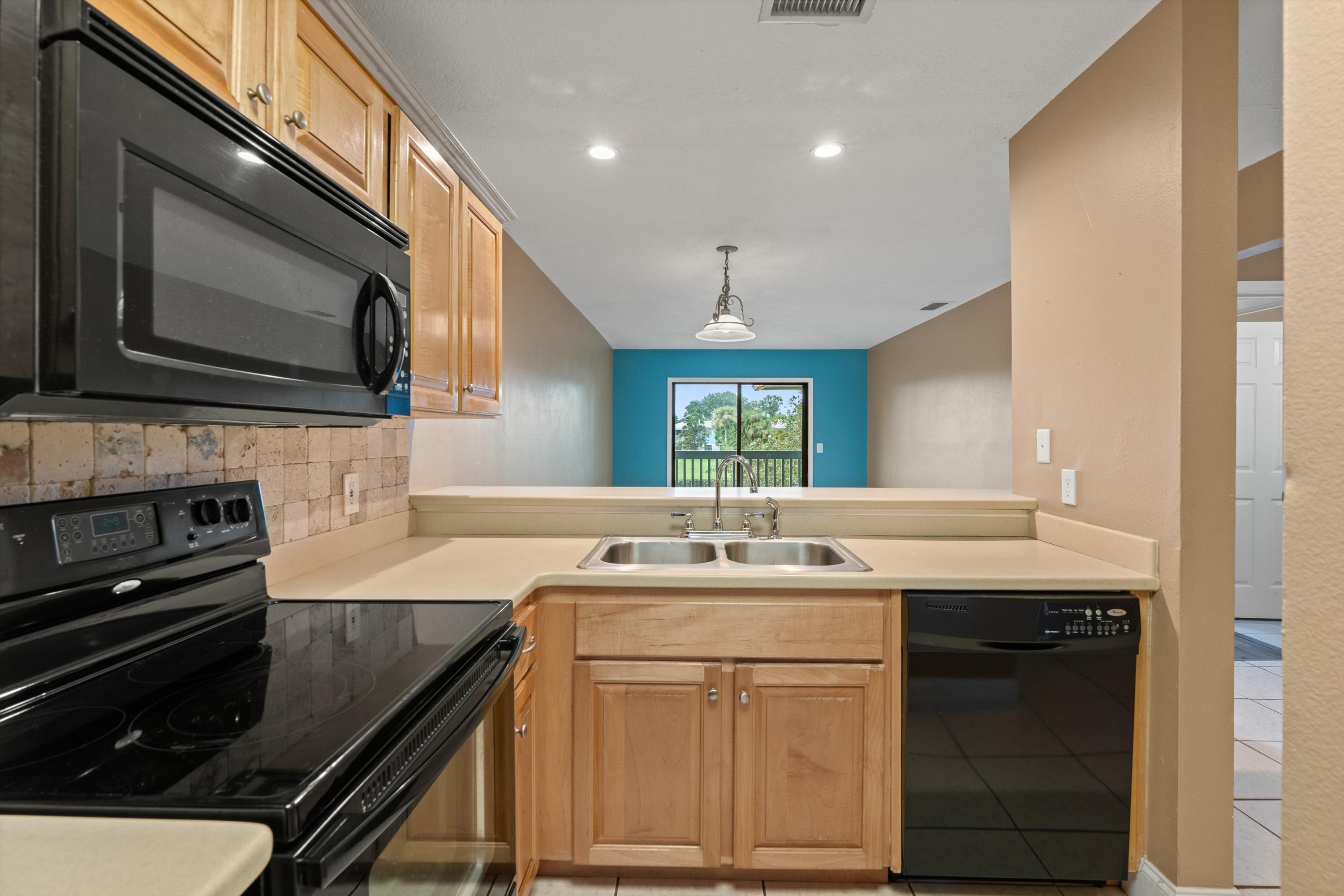 650 West Pope Road, Unit 208 St. Augustine, FL 32080 - Photo 9 of 35 a kitchen with a sink stove and microwave