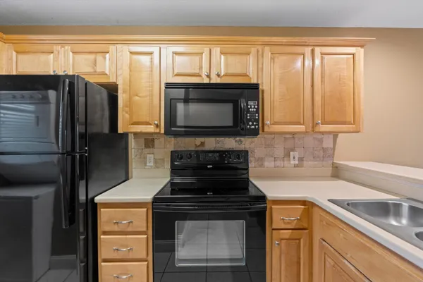 a kitchen with granite countertop a stove and a refrigerator