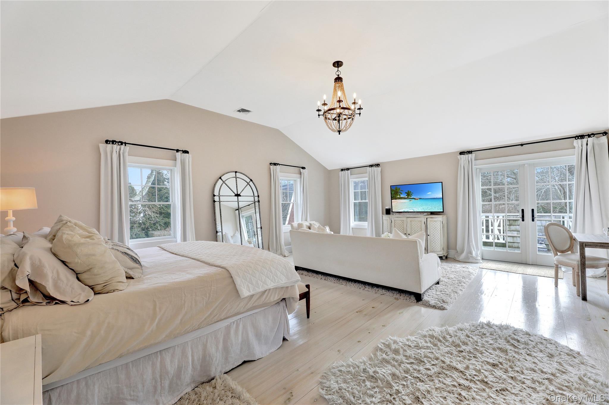 198 South Country Road Remsenburg, NY 11960 - Photo 20 of 49 a spacious bedroom with a bed a couch and wooden floor