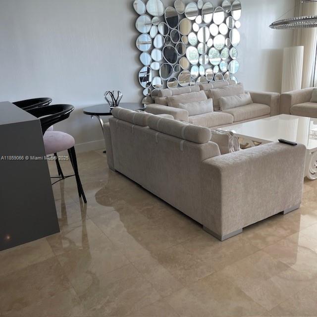 20201 East Country Club Drive, Unit 704 Aventura, FL 33180 - Photo 17 of 46 a living room with furniture and a chandelier