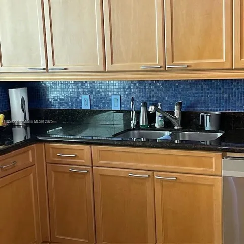 a kitchen with granite countertop stainless steel appliances a stove microwave and door