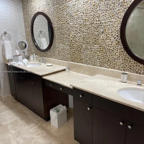 a white toilet sitting next to a white sink and vanity