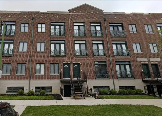 a front view of a residential apartment building with a yard