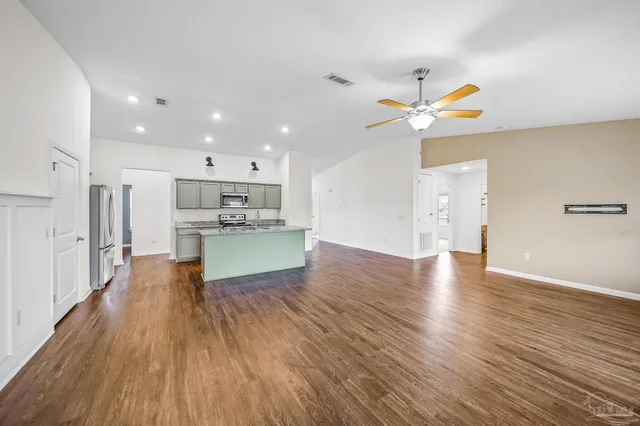 a view of kitchen with a refrigerator wooden floor and a ceiling fan