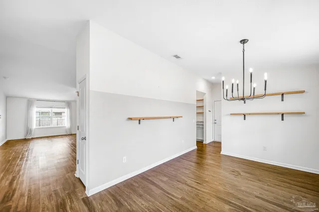 a view of empty room with wooden floor and window