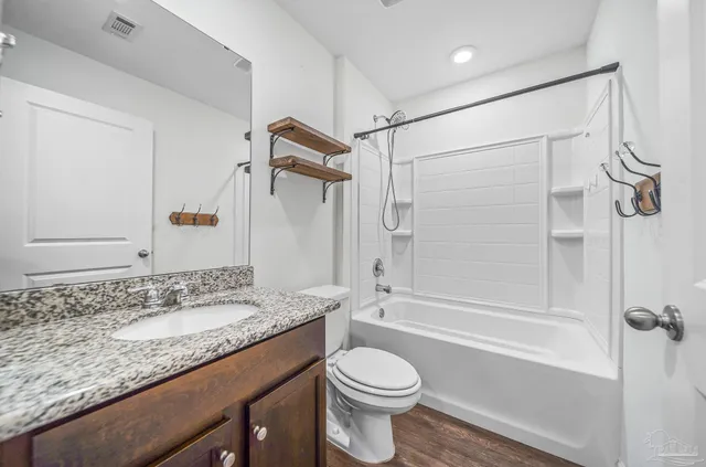a bathroom with a granite countertop sink toilet and shower