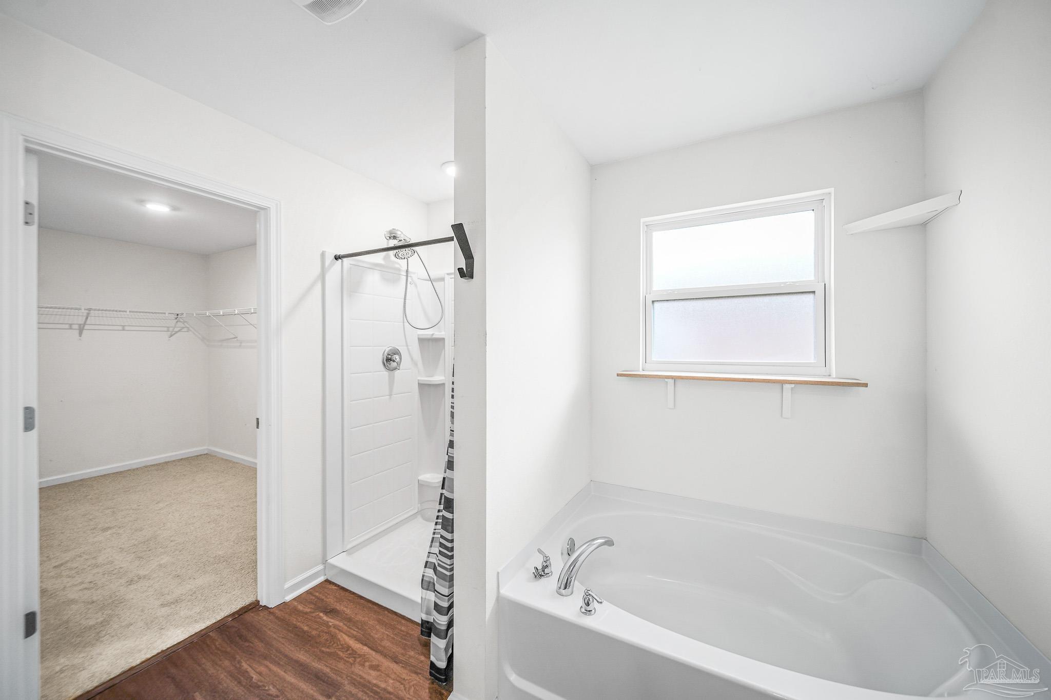 4706 Determination Court Milton, FL 32570 - Photo 29 of 34 a bathroom with a bathtub and a shower