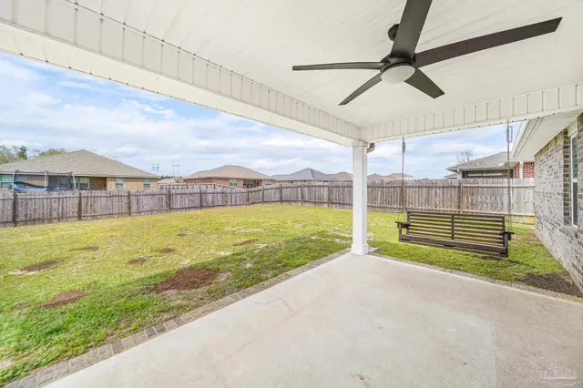 a view of an swimming pool with a big yard and large tree