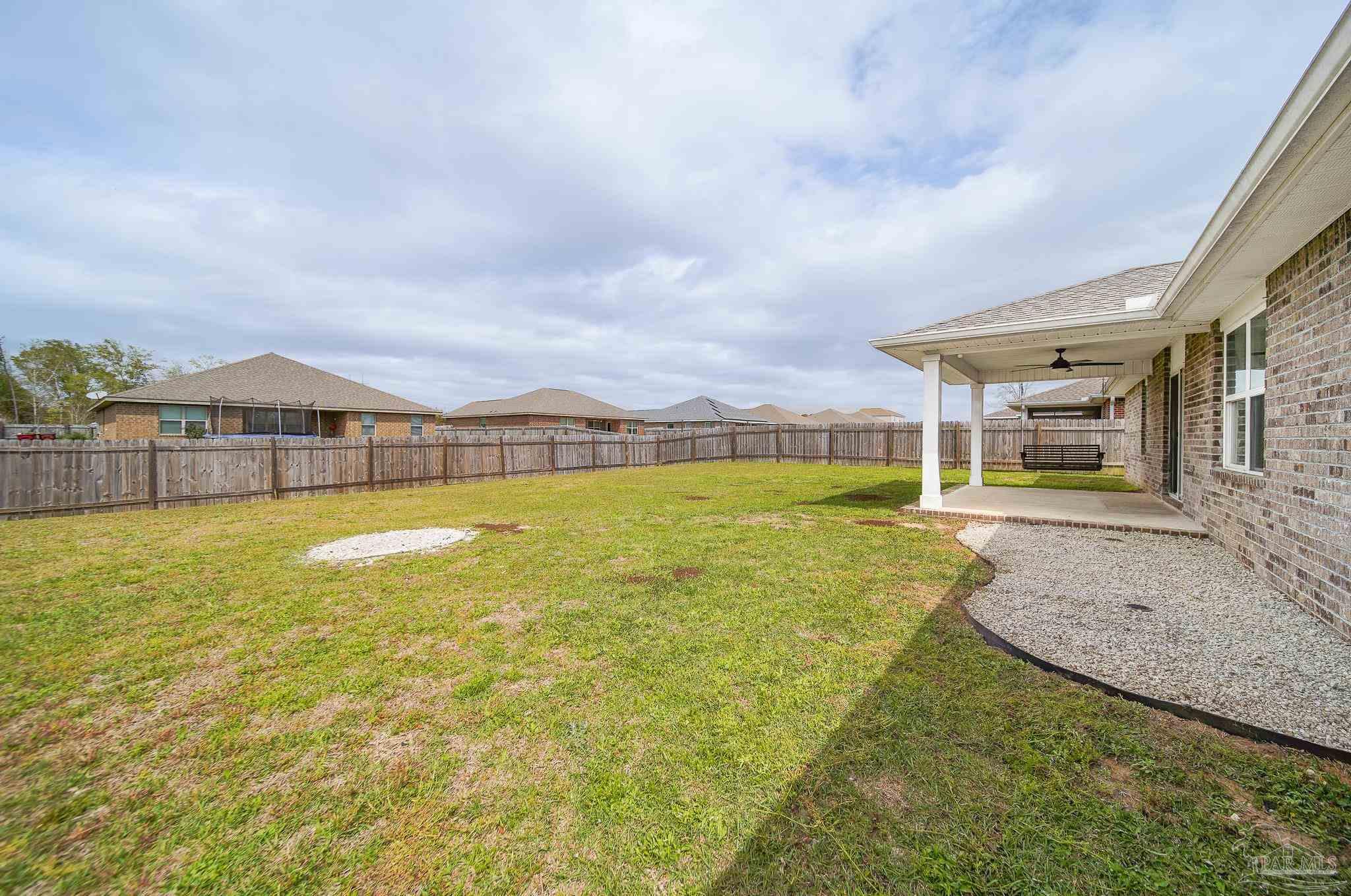 4706 Determination Court Milton, FL 32570 - Photo 32 of 34 a view of an swimming pool with a big yard and large tree