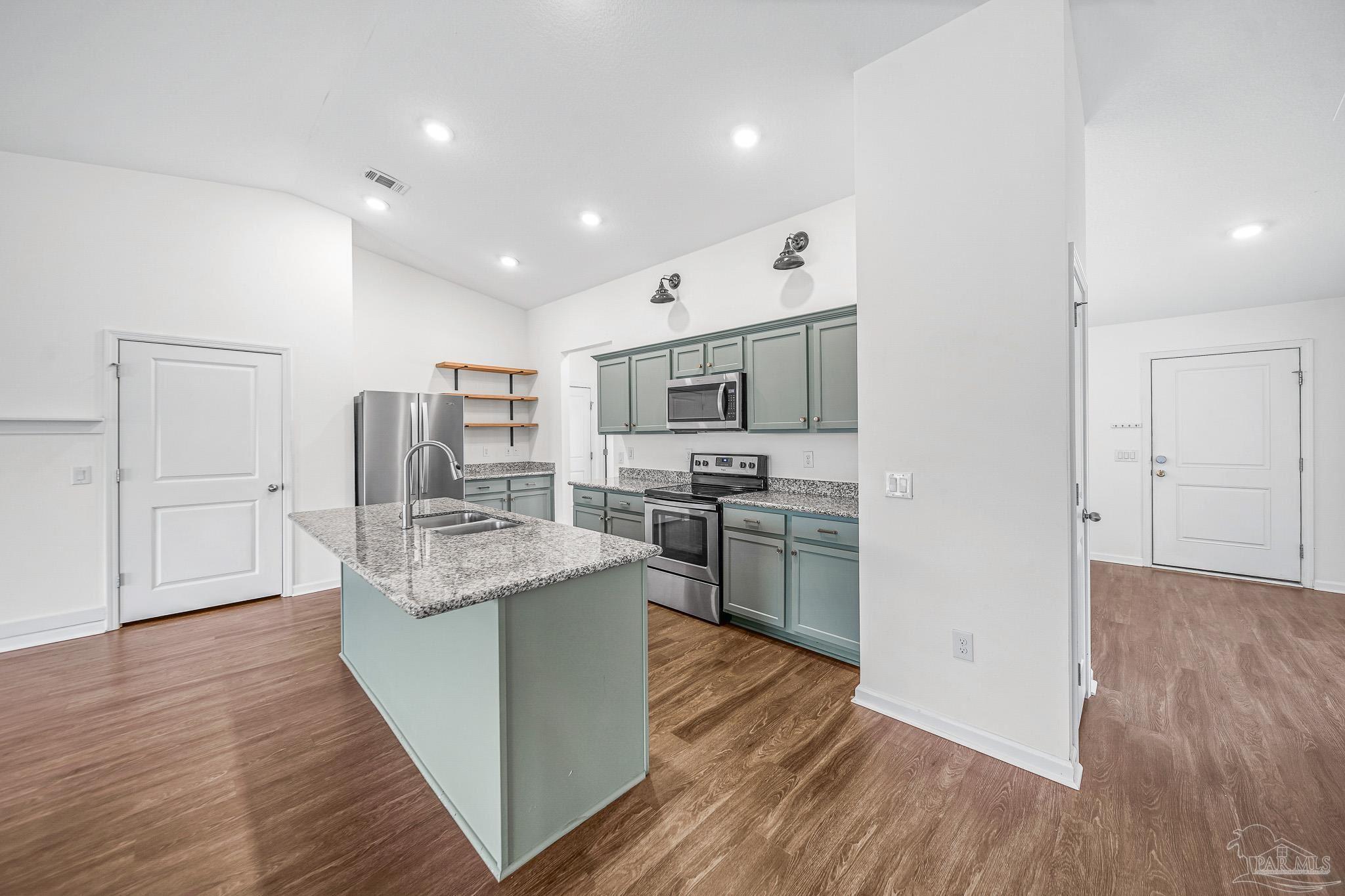 4706 Determination Court Milton, FL 32570 - Photo 5 of 34 a kitchen with stainless steel appliances granite countertop a refrigerator oven a sink dishwasher and white cabinets with wooden floor