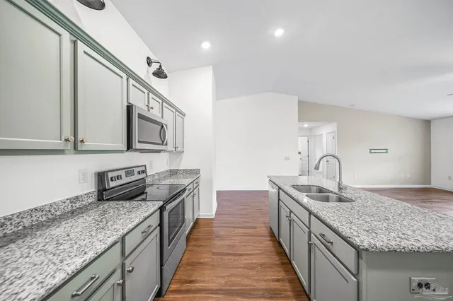 a kitchen with stainless steel appliances granite countertop a sink stove and cabinets