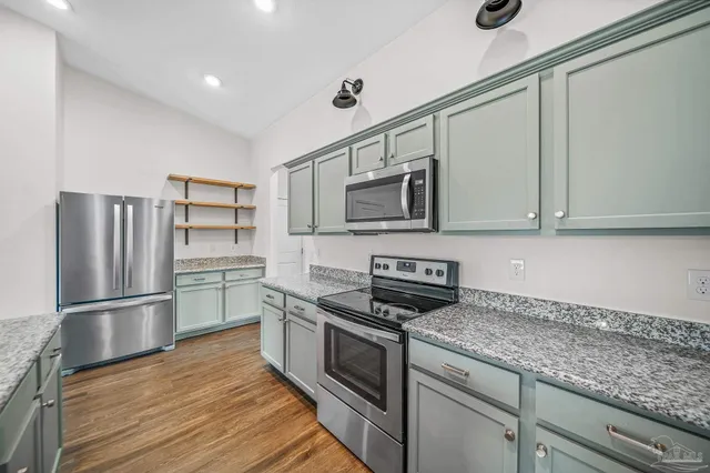 a kitchen with stainless steel appliances granite countertop a refrigerator stove and microwave