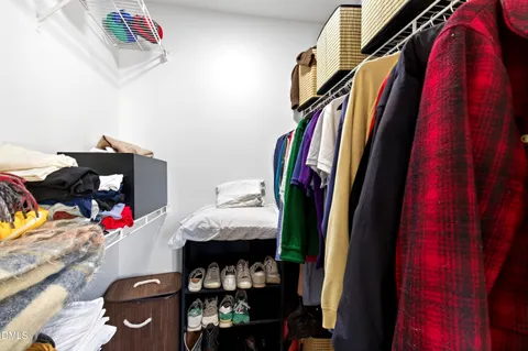 a view of walk in closet with clothes and shoes