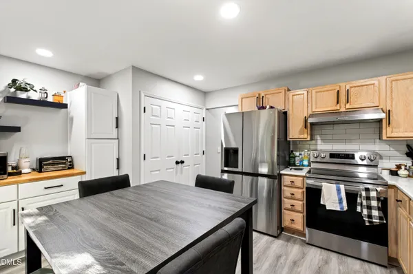 a kitchen with stainless steel appliances granite countertop a refrigerator stove top oven and sink